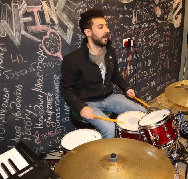 Gilad playing drums in a studio
